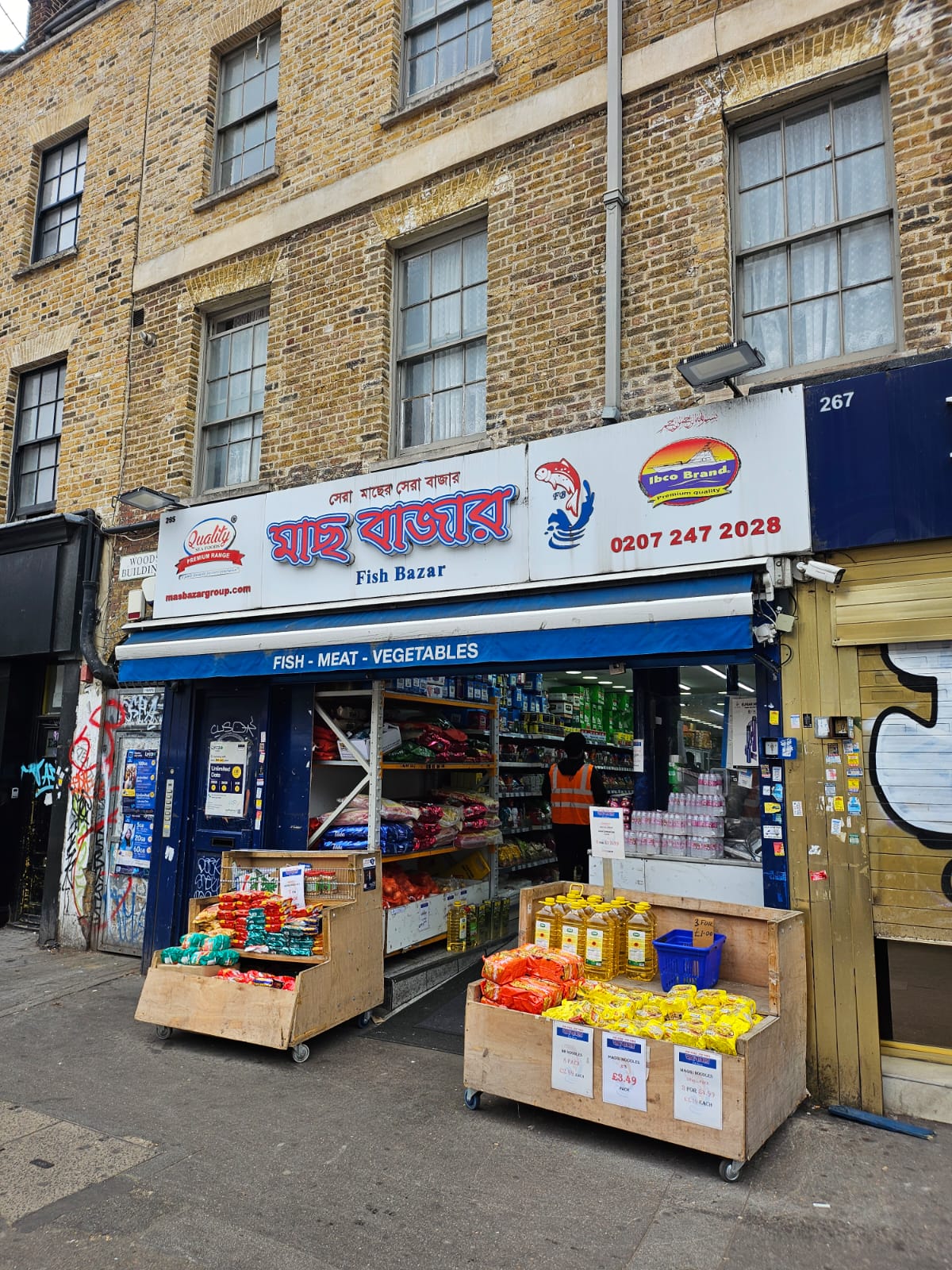 A shop frontage on a London street. There are displays of products on the pavement and as you look into the shop there are ceiling high shelves full of products. 