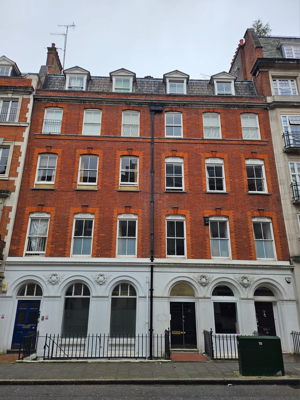 39 Welbeck Street. a typical London townhouses, with four stories and attics, rectangular Georgian windows and a plastered ground floor and brick above.