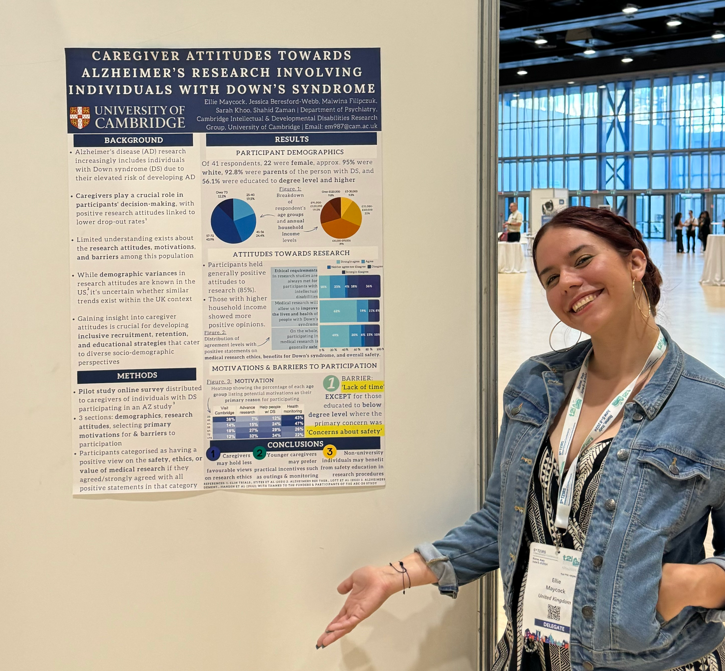 Ellie stands in front of her research poster, entitled Caregiver attitudes towards Alzheimer's research involving individuals with Down's syndrome