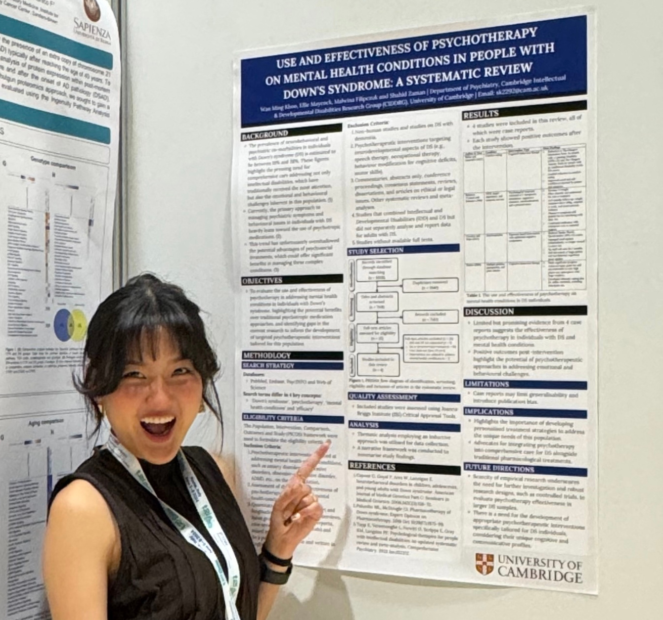 Sarah stands in front of her research poster entitled Use and effectiveness of psychotherapy on mental health conditions in people with Down's syndrome: a systematic review