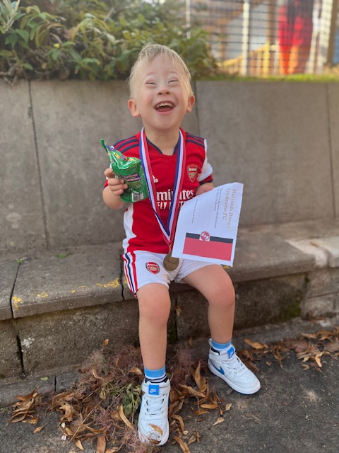 Football fan Rory smiling and holding a certificate